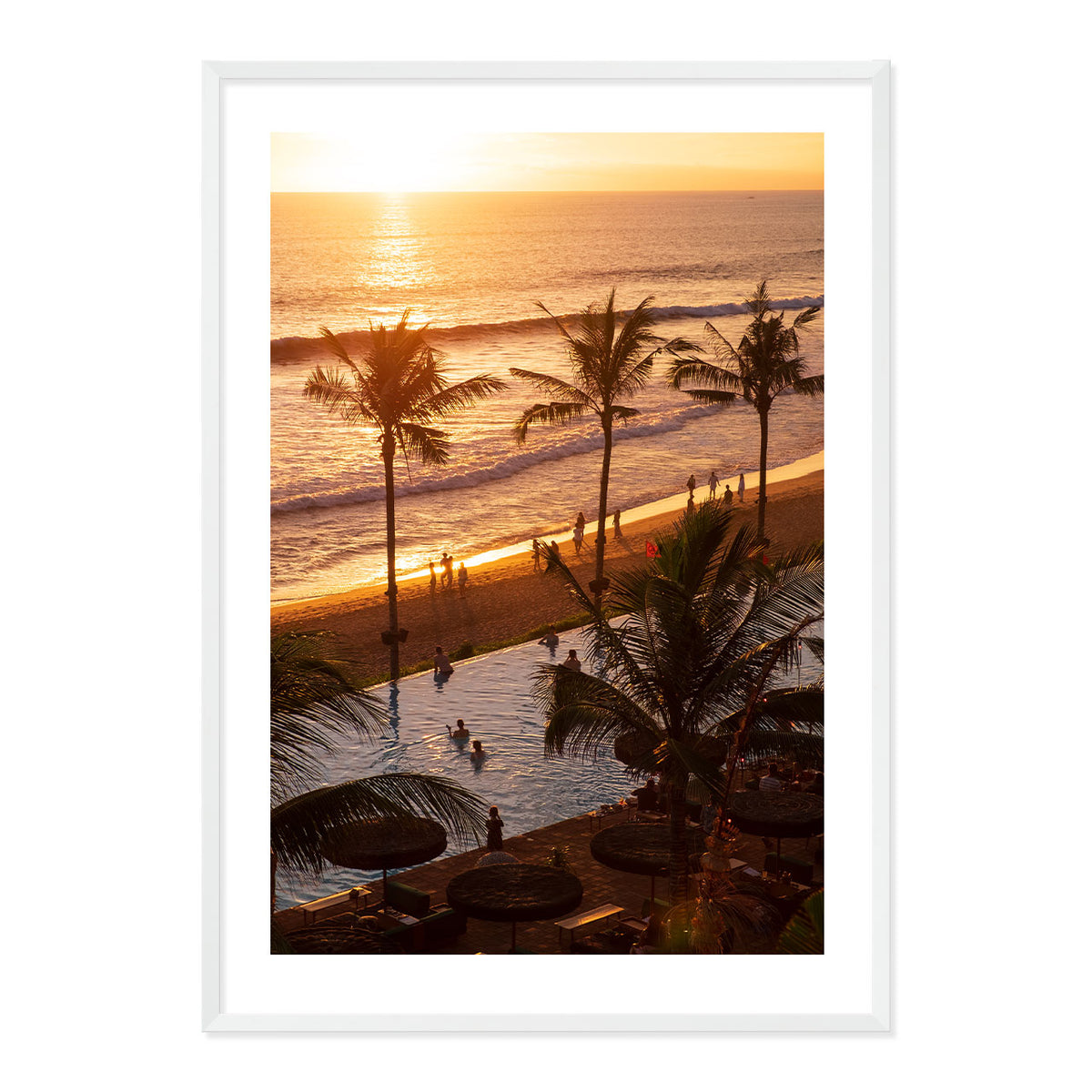 Framed artwork of a sunset over a beach with palm trees and people.