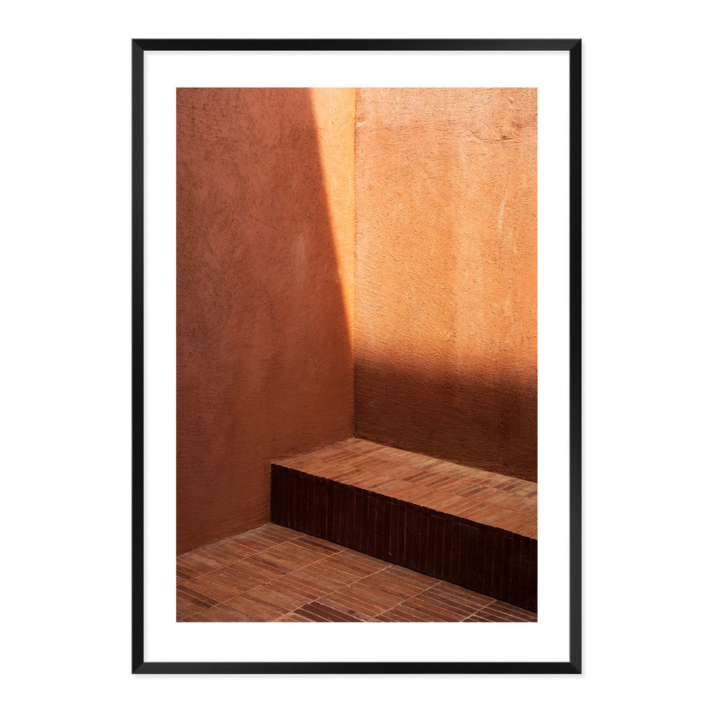 Framed photograph of a room with brown walls and a wooden floor.