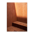 Rust-colored wall with a bench and shadow on a white background